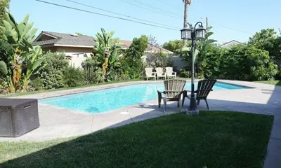 a pool with two chairs and a table next to it at Destination #15 in Anaheim