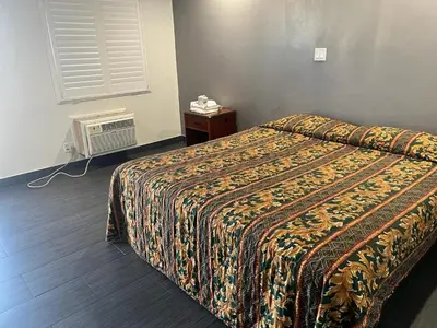 a hotel room with a bed and a television at Pomona Inn in Pomona