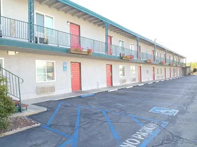 a parking lot in front of a building with blue paint at Pomona Inn in Pomona