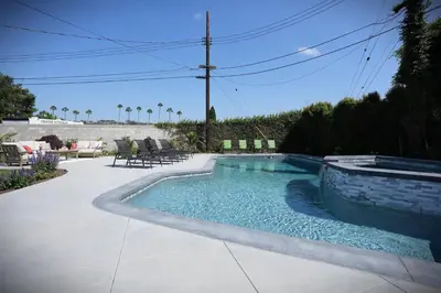 a swimming pool in a patio with chairs around it at Destination #47 in Orange