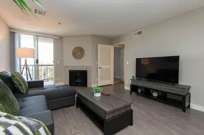 a living room with a couch and a flat screen tv at Hollywood 1Bed Apt w Rooftop pool & Panoramic View in Los Angeles