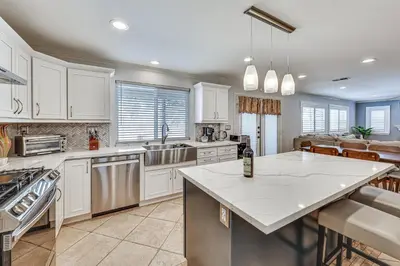 a kitchen with white cabinets and a large island at Large Rancho Cucamonga Home 5 Mi to Red Hill Park in Rancho Cucamonga