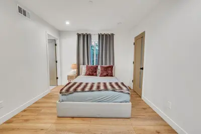 a white bedroom with a bed and a window at Luxurious Townhome W/3 Master Suites gated Parking in Los Angeles
