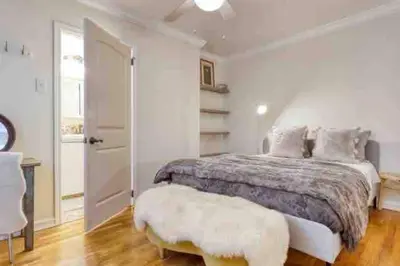 a white bedroom with a bed and a white door at Belmont Shore Beach Bungalow, 2 min walk to town! in Long Beach