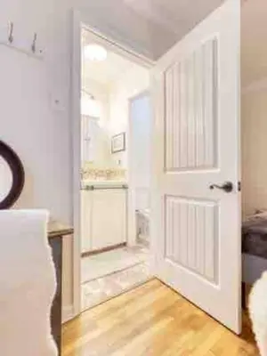 a white door in a room with a wooden floor at Belmont Shore Beach Bungalow, 2 min walk to town! in Long Beach