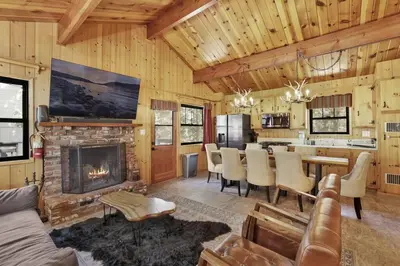 a living room with a fireplace and a dining room at Bruin Chalet Big Bear~ Cozy Single Level Retreat Cottage~ in Big Bear Lake