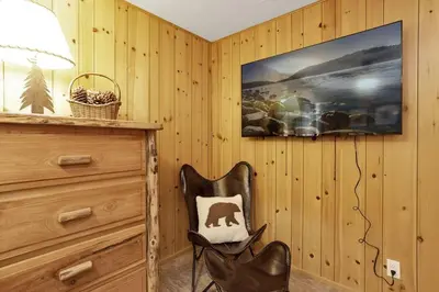 a black chair sitting next to a dresser in a room at Bruin Chalet Big Bear~ Cozy Single Level Retreat Cottage~ in Big Bear Lake