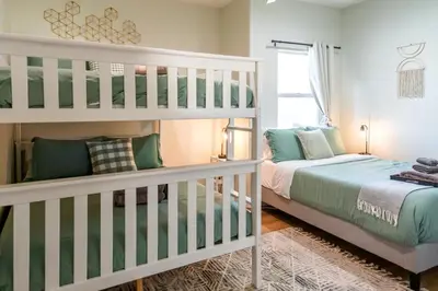 a bedroom with two beds and a bunk bed at Family Getaway Villa to Disneyland! Sleeps up to 22 persons w Game Room, Pool Table & EV Friendly in Midway City