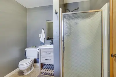 a bathroom with a shower with a toilet and a sink at Woodsy Lake Arrowhead Cabin with Fire Pit Table in Lake Arrowhead