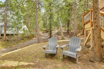 two chairs and a table in front of a house at Woodsy Lake Arrowhead Cabin with Fire Pit Table in Lake Arrowhead
