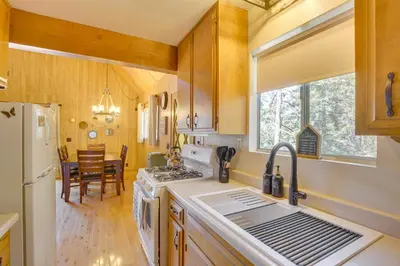 a kitchen with a sink and a stove top oven at Woodsy Lake Arrowhead Cabin with Fire Pit Table in Lake Arrowhead
