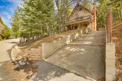 a stone retaining wall in front of a house at Woodsy Lake Arrowhead Cabin with Fire Pit Table in Lake Arrowhead