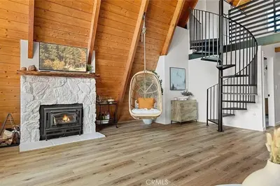 a living room with a fireplace and a staircase at The Scandia “A-Frame Chalet” Fireplace & Hot tub in Running Springs