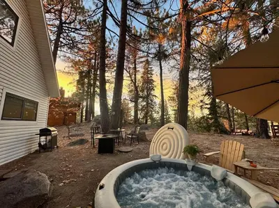 a hot tub in a yard next to a house at The Scandia “A-Frame Chalet” Fireplace & Hot tub in Running Springs