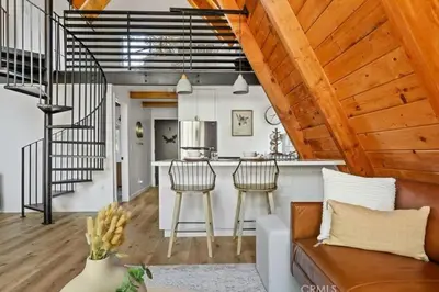 a kitchen and living room with a couch and a counter at The Scandia “A-Frame Chalet” Fireplace & Hot tub in Running Springs