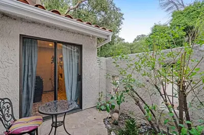 a patio with a table and chairs in a yard at The Malibu Retreat Private Compound w/ Salt Water Pool + Views in Malibu