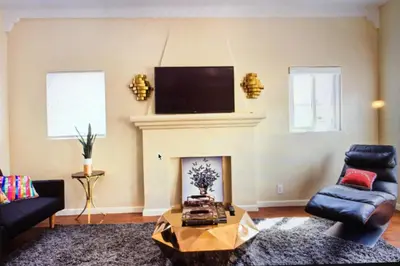 a living room with a fireplace and a tv on the wall at Luxury 2 Bedroom Suite Apartment in Koreatown in Los Angeles