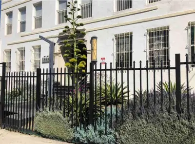 a black fence in front of a white building at Stylish Apartment in Koreatown! Central Location!! in Los Angeles