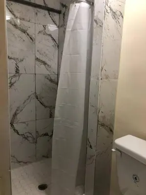 a bathroom with a shower curtain and a toilet at Stylish Apartment in Koreatown! Central Location!! in Los Angeles