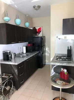 a kitchen with black cabinets and a black refrigerator at Murano Studio in the Heart of Koreatown in Los Angeles