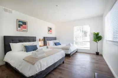 a white bedroom with two beds and a couch at New Renovated Spacious 3 bedroom near DT Alhambra in Alhambra