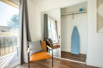a living room with a chair and a mirror at New Renovated Spacious 3 bedroom near DT Alhambra in Alhambra