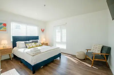 a bedroom with a king sized bed and a chair at New Renovated Spacious 3 bedroom near DT Alhambra in Alhambra