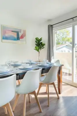 a dining room with a table and white chairs at New Renovated Spacious 3 bedroom near DT Alhambra in Alhambra