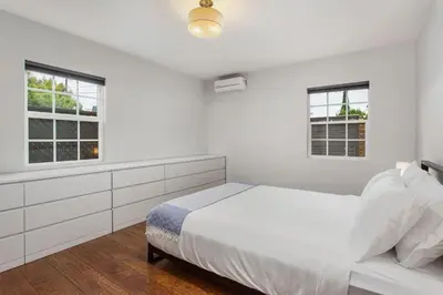 a white bedroom with a bed and two windows at Downtown Culver City House w/ Backyard, AC & Garage in Los Angeles