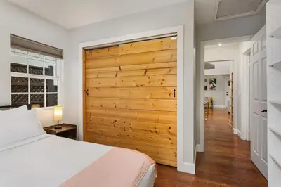 a bedroom with a wooden sliding barn door at Downtown Culver City House w/ Backyard, AC & Garage in Los Angeles