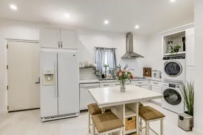 a kitchen with white appliances and a table and chairs at 9 Mi to Dodger Stadium! East LA Studio with Patio in East Los Angeles