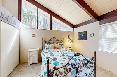 a bedroom with a bed in a room with windows at Fernrock Cabin in Twin Peaks