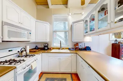 a kitchen with white cabinets and a stove top oven at Fernrock Cabin in Twin Peaks