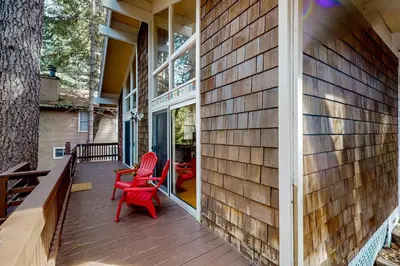 a porch with two red chairs on a house at Fernrock Cabin in Twin Peaks