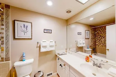 a bathroom with a sink and a toilet and a mirror at Fernrock Cabin in Twin Peaks