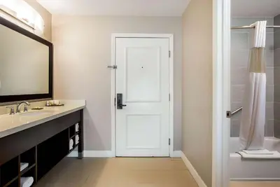 a bathroom with a white door and a sink at La Quinta by Wyndham Pomona in Pomona