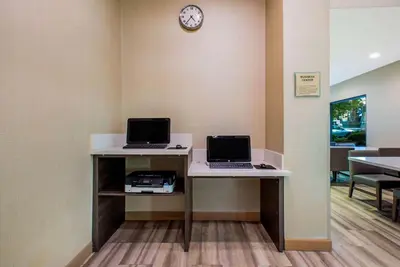 an office with two computers on a desk with a clock at La Quinta by Wyndham Pomona in Pomona