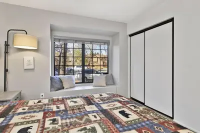 a bedroom with a bed and a window at Restmoore Big Bear~ Lakeside Condo Retreat~ in Big Bear Lake
