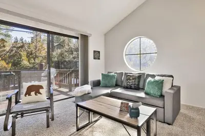 a living room with a couch and a table at Restmoore Big Bear~ Lakeside Condo Retreat~ in Big Bear Lake