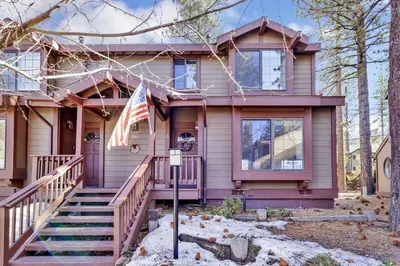 a house with an american flag in front of it at Restmoore Big Bear~ Lakeside Condo Retreat~ in Big Bear Lake