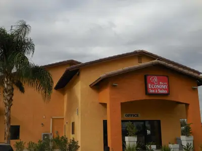 a brown building with a red sign on it at Best Economy Inn & Suites in Bakersfield
