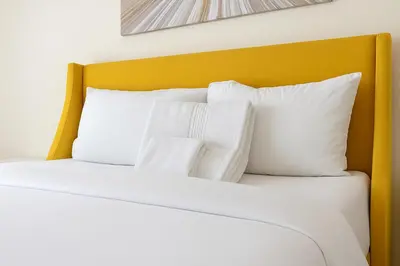 a bed with white pillows and a yellow headboard at Adorable and Bright 2BD 2BR 740 in Los Angeles