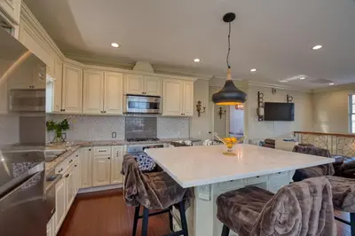 a kitchen with white cabinets and a island with bar stools at Luxury 2 bed 1 bath in Torrance
