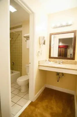 a bathroom with a sink and a toilet and a mirror at Bokai Garden Hotel in Rosemead