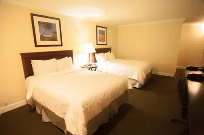 a hotel room with two beds and a lamp at Bokai Garden Hotel in Rosemead
