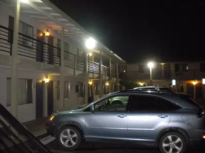 a car parked in front of a building at night at Wasco Inn in Wasco