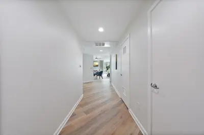 an empty hallway with white walls and wood floors at The Turquoise Lounge - Chic 2BR Beach view Pool, Sauna in Los Angeles