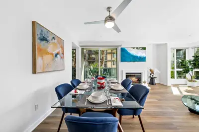 a dining room with a table and blue chairs at The Turquoise Lounge - Chic 2BR Beach view Pool, Sauna in Los Angeles