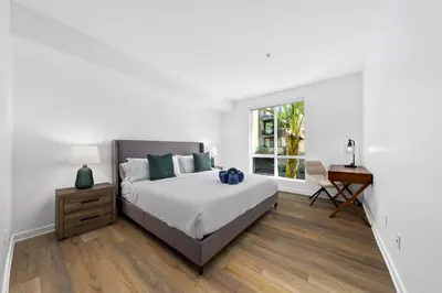 a bedroom with a bed and a desk and a window at The Turquoise Lounge - Chic 2BR Beach view Pool, Sauna in Los Angeles