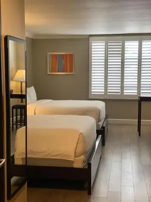 a room with two beds and a mirror at GreenTree Inn & Suites Los Angeles - Alhambra - Pasadena in Alhambra